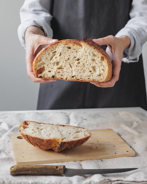 Woman baker cooks bread in the kitchen a cook in a pastry shop holds bread in her hands