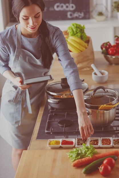 照片的女人在家烤食谱在平板电脑上