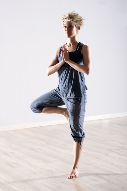 Foto donna in equilibrio su una gamba sola in posizione yoga