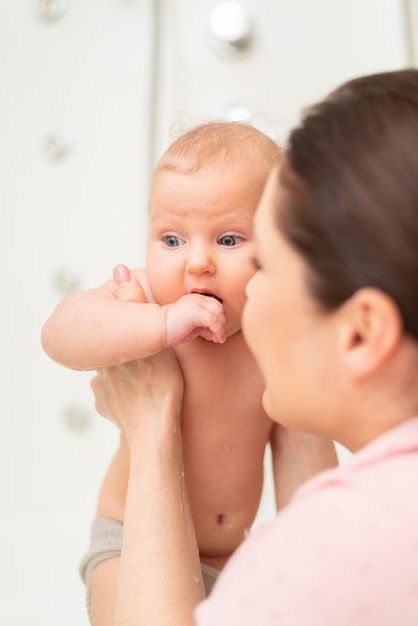 Woman bathes her baby in the bathroom