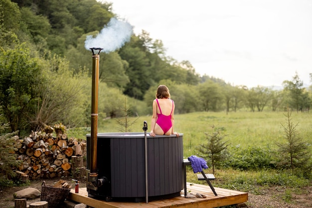 Woman bathing in hot tub on nature