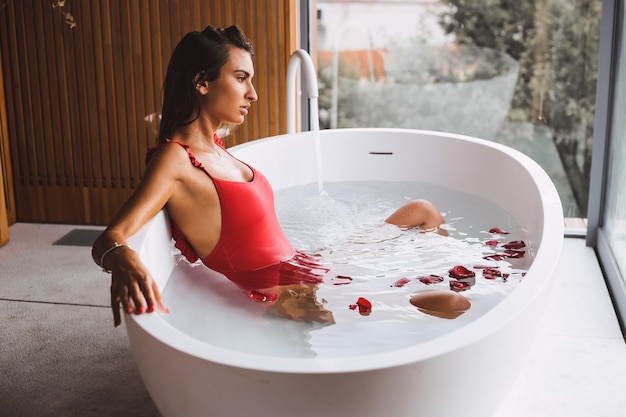 Woman bathing and relaxing in a modern bath tub