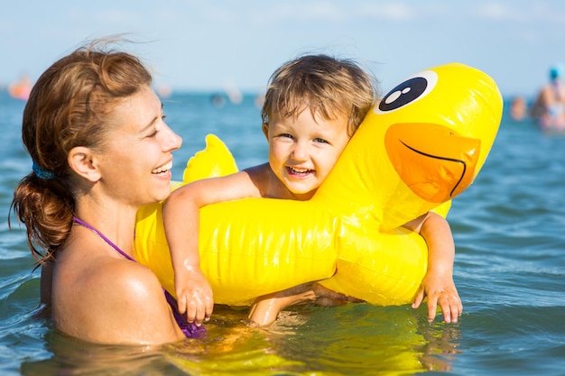 Donna che fa il bagno in mare con un bambino