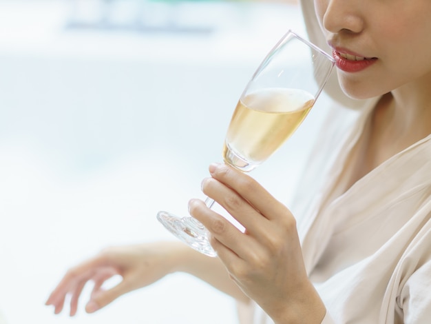 Woman in bathrobe drinking wine.