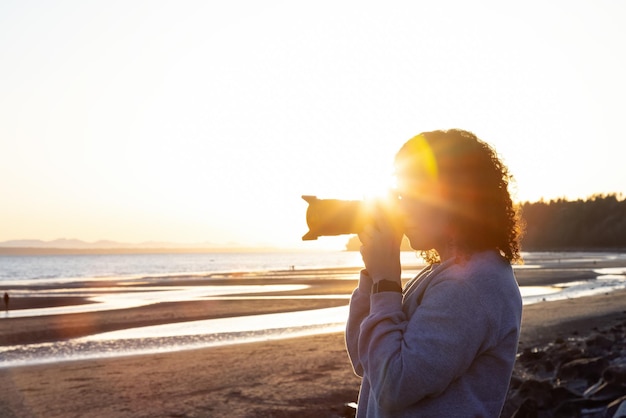 Photo woman at beach against sky during sunset