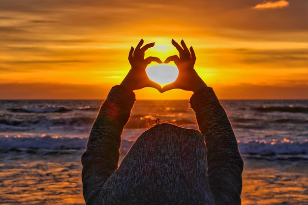 Foto donna sulla spiaggia contro il cielo durante il tramonto