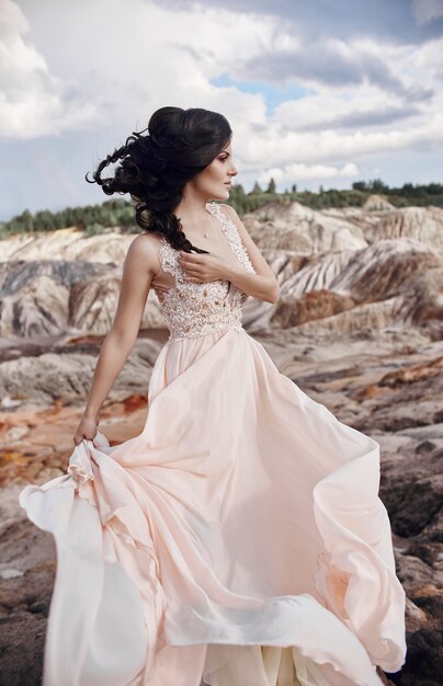 Woman in a beautiful pink dress in the fabulous mountains. 