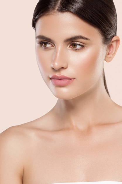 Woman beauty face healthy clean skin natural makeup beauty eyes female young model Beige background.