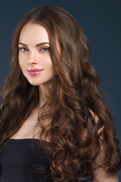 Woman beauty healthy skin and hairstyle brunette  long hair over dark background. Studio shot.