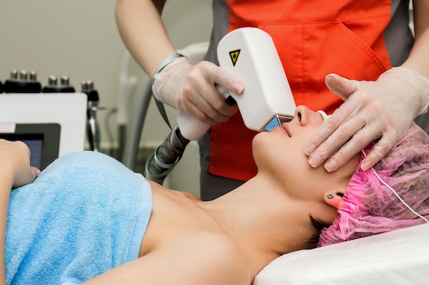 A woman in a beauty salon takes a procedure for laser depilation of the upper lip