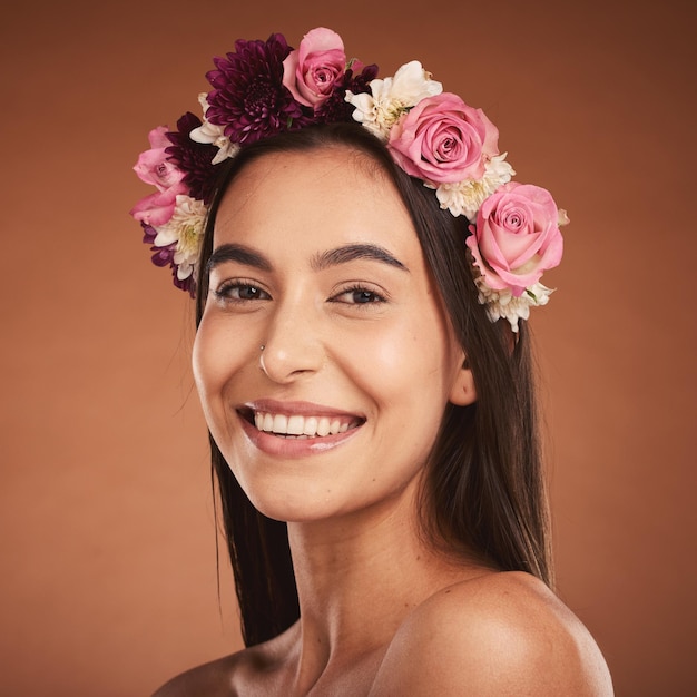 Woman beauty smile and flower headband for spring portrait Young happy girl natural cosmetic makeup and healthy facial skincare wellness glow with floral rose band in orange background studio