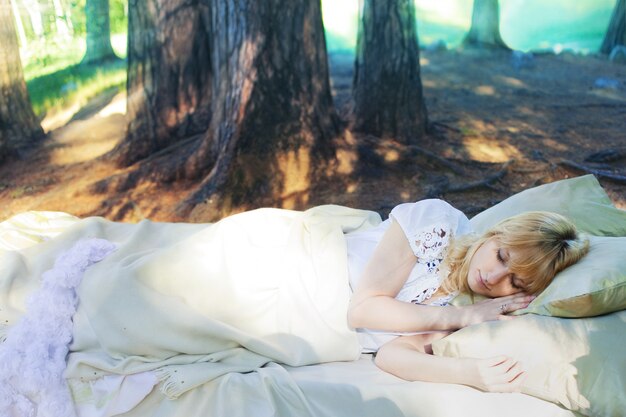 Woman in a bed in the forest