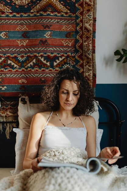 a woman in bed with a book photo