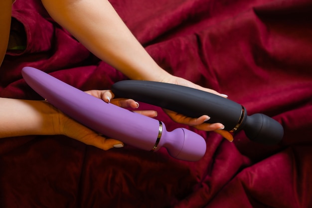 Woman in bedroom holding vibrator in hand