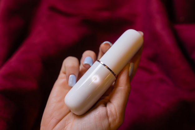 Photo woman in bedroom holding vibrator in hand