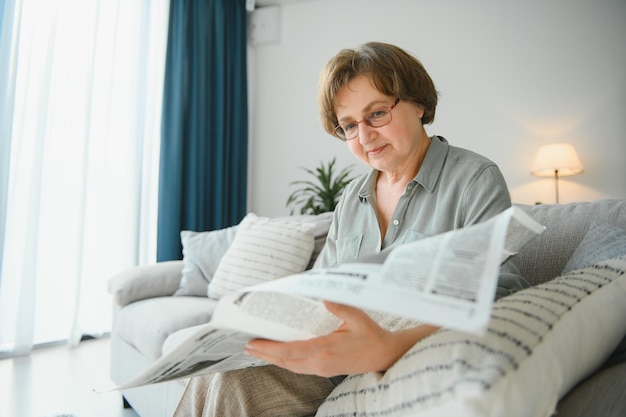 Donna in camera da letto con giornale sorridente