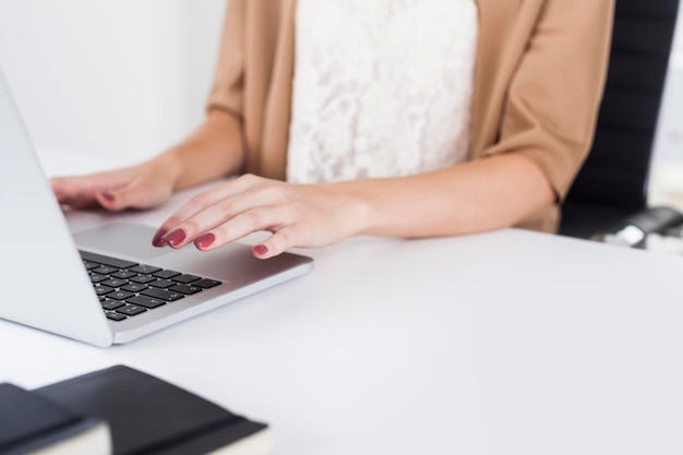 Woman in beige cardigan typing