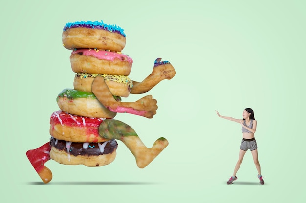 Photo woman being chased by doughnuts in lime green