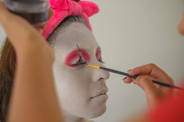 Woman being made up as a clown