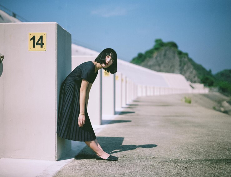 Photo 晴れた日に街の壁に寄りかかっている女性