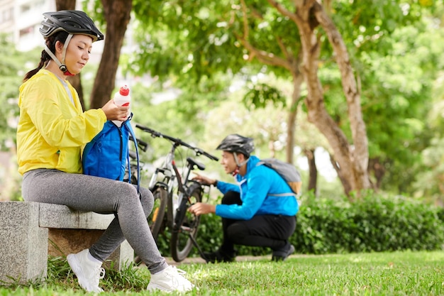 Woman in Bicycle Helmet Drinking Water