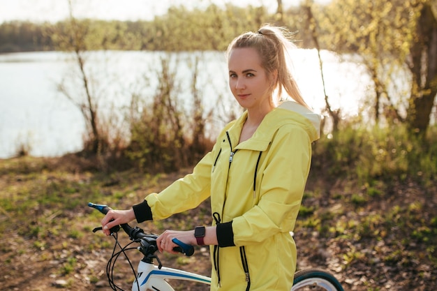 森の中で黄色いレインコートを着た自転車に乗った女性