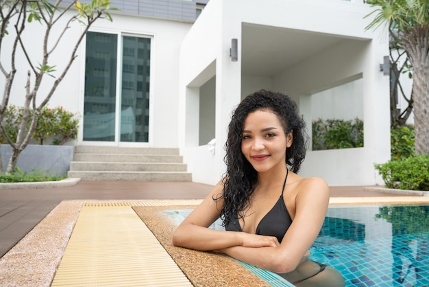 Woman in the bikini at pool Swimming pool tanned slim and shapely body Girl enjoying travel holidays at resort luxury overwater bungalow