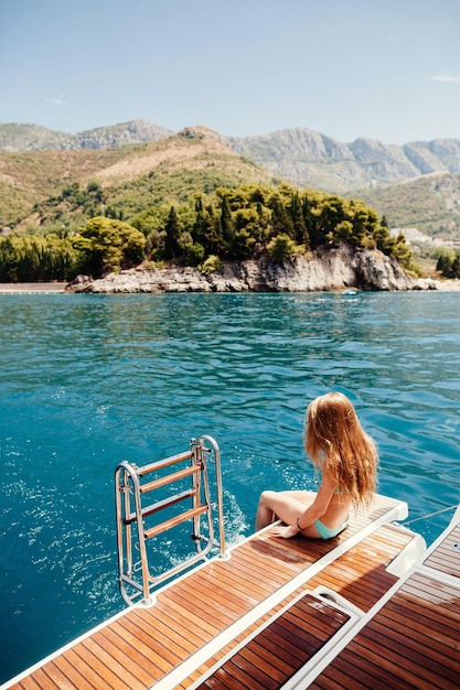 Woman in bikini sitting by sea