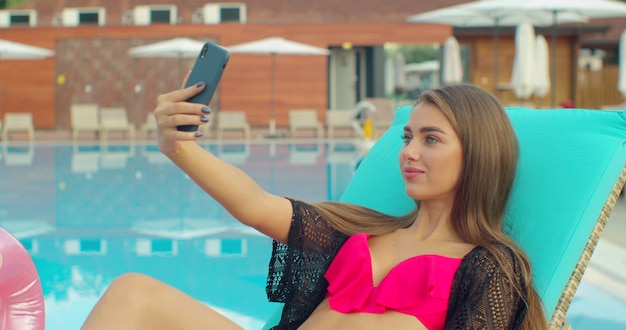 Photo woman in bikini taking selfie photo on pool, summer vacation
