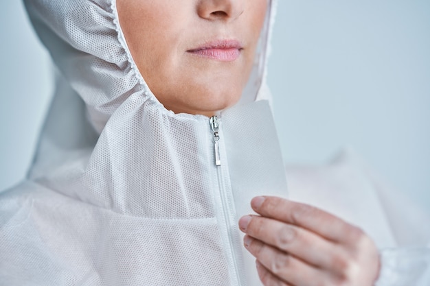 woman in bio-hazard suit over white background.