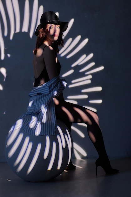 Woman in black bodysuit in the backlight of a photo studio