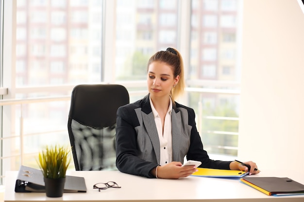 woman in a black businesswoman jacket works in a bright office