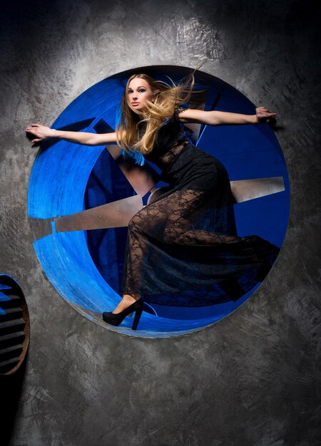 Woman in a black dress on a background of a fan.