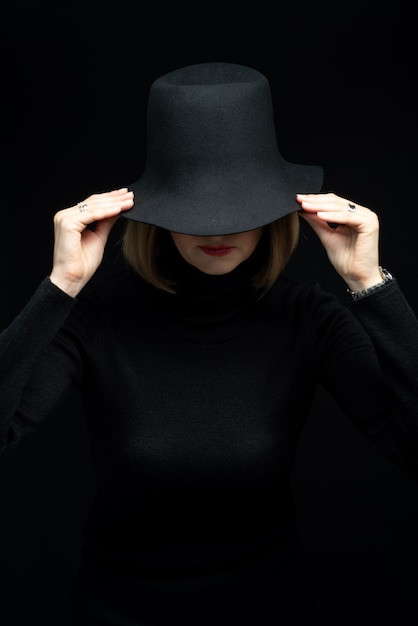 Woman in black dress and black hat