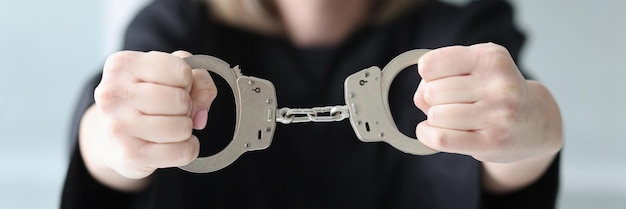 Photo a woman in a black dress holds handcuffs a closeup judge in a black mantle accusative sentence