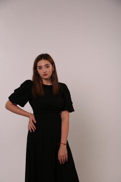 黒いドレスを着た女性が写真を撮るポーズをとる