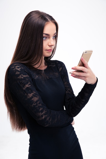 Женщина в черном платье с помощью смартфона
