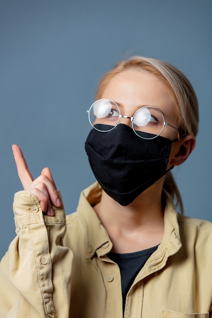 Woman in black face mask on grey space