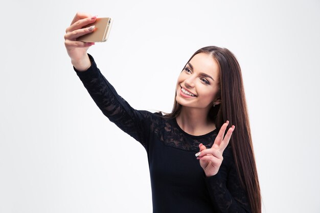 セルフィー写真を作る黒いファッションドレスの女性