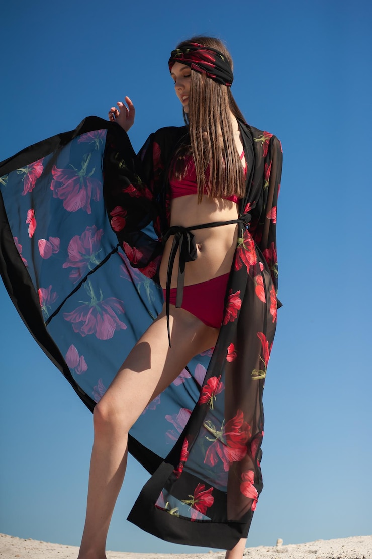 Photo a woman in a black kimono with red flowers on it