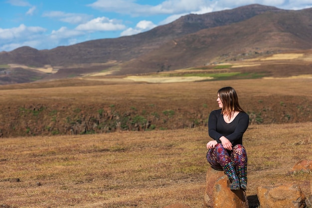 Woman in black looking out over the grasslands of the highlands of lesotho africa