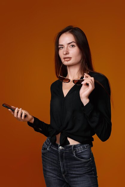 Woman in black shirt and jeans using mobile cell phone person