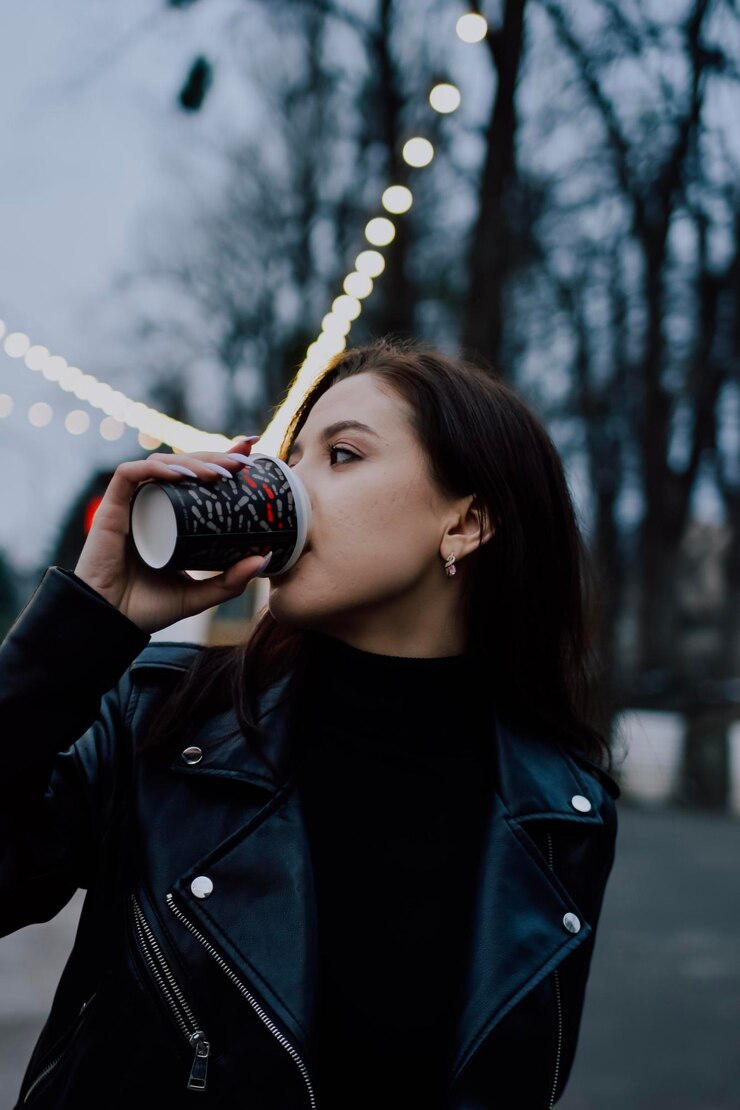 Photo woman in black wear drinking coffee in park