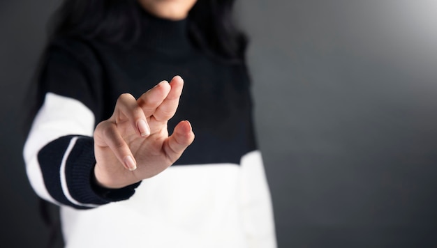 Photo a woman in a black and white sweater pointing at something