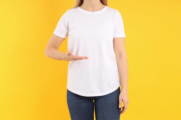 Woman in blank white t-shirt on yellow background