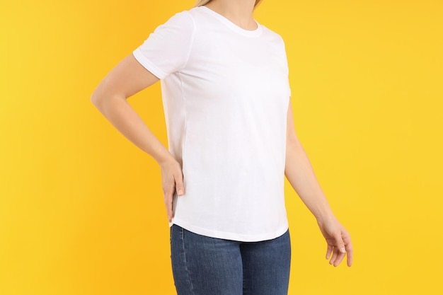 Woman in blank white t-shirt on yellow background