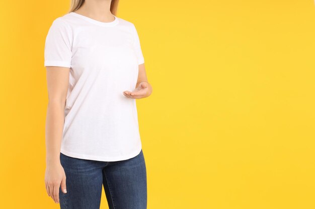 Woman in blank white t-shirt on yellow background