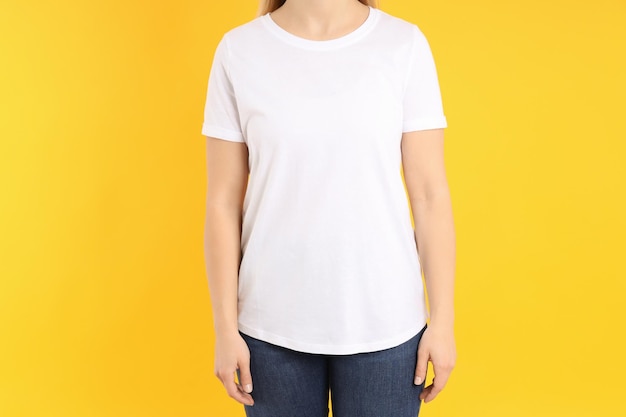 Woman in blank white t-shirt on yellow background