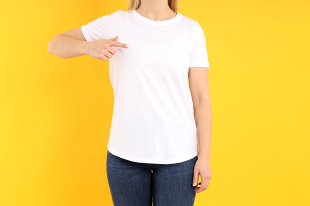 Woman in blank white t-shirt on yellow background