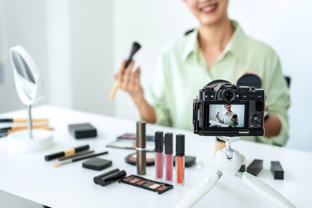 Photo woman blogger is present make up tutorial beauty cosmetic review product and broadcast live streaming video to teaching online on the camera screen at office studio